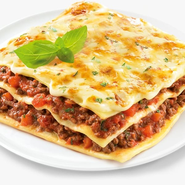 A square serving of lasagna with layers of pasta, meat sauce, and melted cheese, garnished with basil.